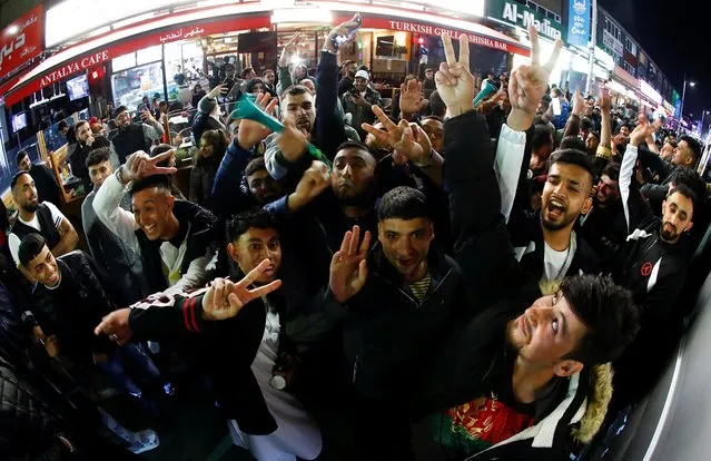 Muslims gesture as they celebrate Eid al-Fitr, marking the end of the month of Ramadan, amid the coronavirus disease (COVID-19) outbreak, in Rusholme, Manchester, Britain, May 13, 2021. Picture taken with a wide-angle lens. (Photo by Jason Cairnduff/Reuters)