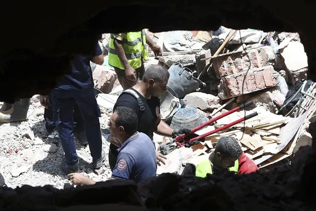 Rescuers search through the rubble of a collapsed five-story apartment building in Cairo, Egypt, Monday, July 17, 2023. A five-story apartment building collapsed Monday in the Egyptian capital of Cairo, leaving several people dead, authorities said, as rescuers at the scene searched through the rubble. Building collapses are common in Egypt, where shoddy construction and a lack of maintenance are widespread in shantytowns, poor city neighborhoods and rural areas. (Photo by AP Photo/Stringer)