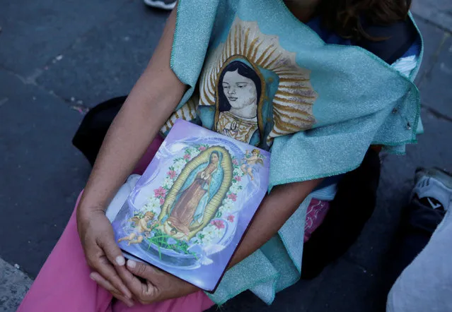 A pilgrim holds images of the Virgin of Guadalupe at the Basilica of Guadalupe during the annual pilgrimage in honor of the Virgin of Guadalupe, patron saint of Mexican Catholics, in Mexico City, Mexico December 11, 2016. (Photo by Henry Romero/Reuters)