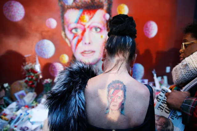 A woman with a Ziggy Stardust tattoo visits a mural of David Bowie in Brixton, south London, January 11, 2016. David Bowie, a music legend who used daringly androgynous displays of sexuality and glittering costumes to frame legendary rock hits “Ziggy Stardust” and “Space Oddity”, has died of cancer. (Photo by Stefan Wermuth/Reuters)