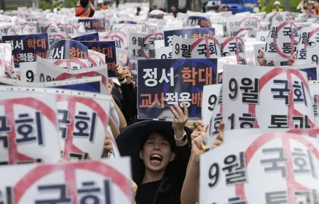 A teacher shouts slogans during a rally to demand the better protection of their rights near the National Assembly in Seoul, South Korea, Saturday, September 16, 2023. Following the suicide of an elementary school teacher in July, teachers across South Korea have been pushing for improved systems to protect teachers from widespread malicious complaints from parents. The sign reads “Grant teachers immunity from child emotional abuse claims”. (Photo by Ahn Young-joon/AP Photo)