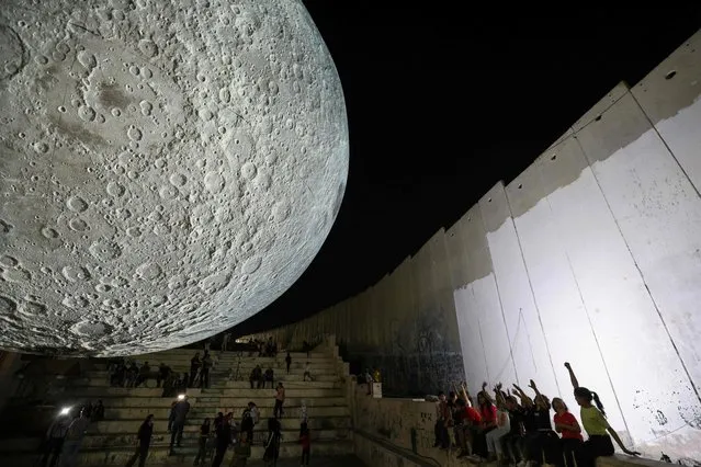 UK artist Luke Jerram’s touring artwork entitled “the Museum of the Moon” is displayed at the Aida camp for Palestinian refugees near Bethlehem in the occupied West Bank, next to Israel's controversial separation barrier on September 16, 2023. (Photo by Hazem Bader/AFP Photo)