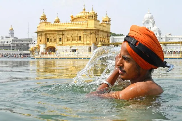 A Sikh devotee takes a bath in the holy sarovar (water tank) on the occasion of the 415th Sikh Guru Arjan Dev's martyrdom day at the Golden Temple in Amritsar on June 14, 2021. (Photo by Narinder Nanu/AFP Photo)