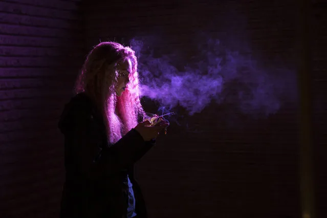 A model smokes a cigarette outside prior to the presentation of the Fall/Winter 2015/16 Ready to Wear collection by British designer Olympia Le Tan during the Paris Fashion Week, in Paris, France, 07 March 2015. The presentation of the Women's collections runs from 03 to 11 March. (Photo by Etienne Laurent/EPA)