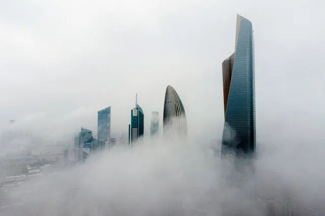 This aerial picture shows highrise buildings during a foggy morning in Kuwait City on March 14, 2023. (Photo by Yasser Al-Zayyat/AFP Photo)