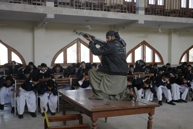 A Pakistani security official poses as a militant during a security drill at the Islamia College, Tuesday, February 2, 2016 in Peshawar, Pakistan, in wake of the militants' attack on the Bacha Khan University which left many dead. (Photo by Mohammad Sajjad/AP Photo)
