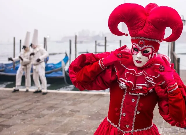 A man wearing a carnival costume poses in front of other two traditional Italian masks on February 2, 2016 in Venice, Italy. The 2016 Carnival of Venice will run from January 23 to February 9 and includes a program of gala dinners, parades, dances, masked balls and music events. (Photo by Marco Secchi/Getty Images)