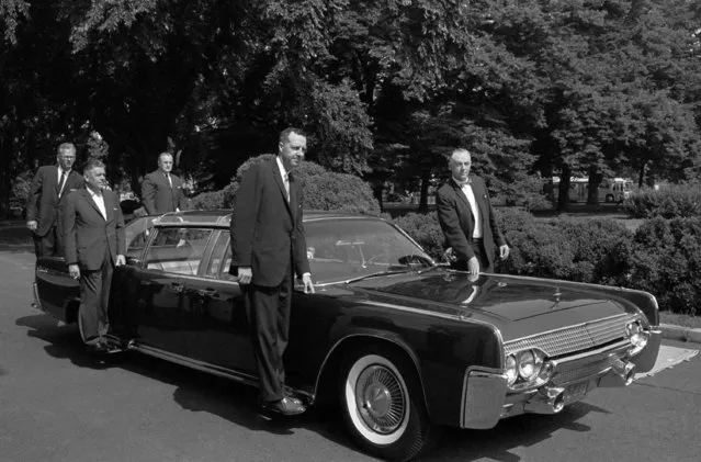 In this June 14, 1961 file photo, U.S. Secret Service agents stand on retractable stands on President John F. Kennedy's new plastic-topped Lincoln Continental limousine outside the White House, after its delivery in Washington. The car has three roof combinations, a rear seat that can be raised and lowered, retractable foot stands for Secret Service men, two two-way radio telephones, and a master control panel for power accessories. (Photo by Henry Burroughs/AP Photo)