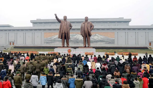 Service personnel and civilians lay flowers before the bronze statue of leader Kim Jong Il on New Year's Day in this photo released by North Korea's Korean Central News Agency (KCNA) in Pyongyang January 1, 2017. (Photo by Reuters/KCNA)