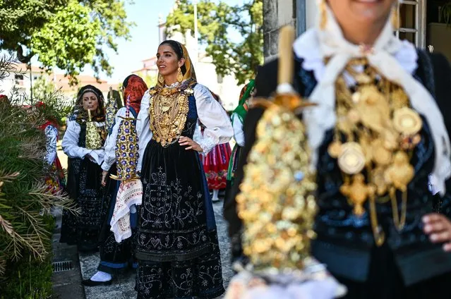 Hundreds of women dressed in traditional folk clothing from their regions walk together carrying their family gold during the Mordomia Parade part of the Festival of Our Lady in Sorrow in Viana do Castelo, Portugal on August 18, 2022. After 2 years break due to the COVID-19 pandemic, the biggest folk religious festival in Portugal gets back to the pre-pandemic formula, bringing one million visitors to the city during the 4 days celebrations. The Mordomia parade, one of the highlights of the festival, brings more than 700 women carrying their family gold through the city streets. This year it is estimated that the gold carried by the women estimates almost 100 million euros. (Photo by Omar Marques/Anadolu Agency via Getty Images)
