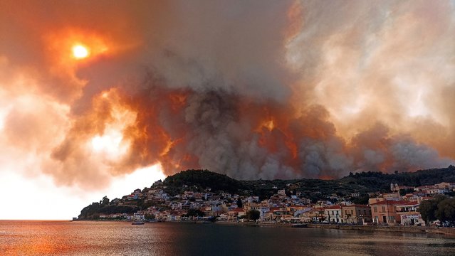 Flames burn on the mountain near Limni village on the island of Evia, about 160 kilometers (100 miles) north of Athens, Greece, Tuesday, August 3, 2021. Greece Tuesday grappled with the worst heatwave in decades that strained the national power supply and fueled wildfires near Athens and elsewhere in southern Greece. As the heat wave scorching the eastern Mediterranean intensified, temperatures reached 42 degrees Celsius (107.6 Fahrenheit) in parts of the Greek capital. (Photo by Michael Pappas/AP Photo)