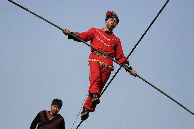 Acrobats perform on a tightrope as the Chinese Lunar New Year, which welcomes the Year of the Monkey, is celebrated at Daguanyuan park, in Beijing, China February 10, 2016. (Photo by Damir Sagolj/Reuters)