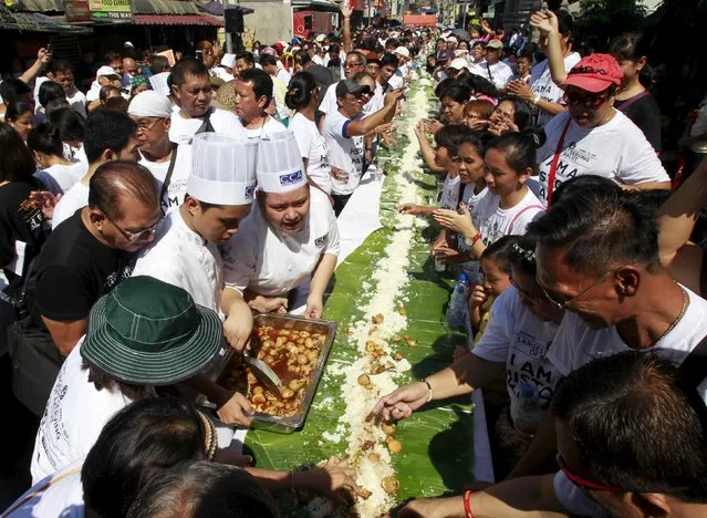 Students from the Center for Culinary Art Manila serve hundreds of Balut, a local delicacy of boiled duck embryo, on banana leaves in preparation for the boodle feast during an attempt to make a Guinness World Record in the Pateros municipality, metro Manila April 10, 2015. (Photo by Romeo Ranoco/Reuters)