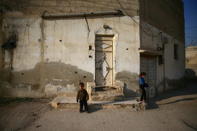 Children stand near the door of a house in the rebel held besieged city of Douma, in the eastern Damascus suburb of Ghouta, Syria January 7, 2017. (Photo by Bassam Khabieh/Reuters)