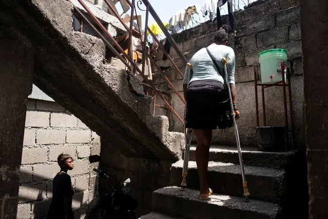 A woman goes up the stairs at a school where people with disabilities and their families have been taking shelter after their settlement was burned down by gangs a month ago, in Port-au-Prince, Haiti July 27, 2021. (Photo by Ricardo Arduengo/Reuters)