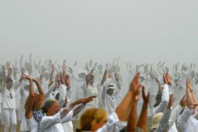 Members of an international religious movement called the White Brotherhood perform ritual dance on the top of the Rila Mountain, near Babreka lake, on August 19, 2021. Thousands of pilgrims gathered on August 19, 2021 in Bulgaria's Rila mountains to welcome their “spiritual” new year with a cosmic-like dance performed in concentric circles, creating a striking image on the verdant mountain plain. The white-clad dancers hiked up to Bulgaria's Seven Rila Lakes at an altitude of 2,100 metres (6,900 feet) and performed a special meditative dance known as “paneurhythmy” for more than an hour under the sound of singing and violins. (Photo by Nikolay Doychinov/AFP Photo)