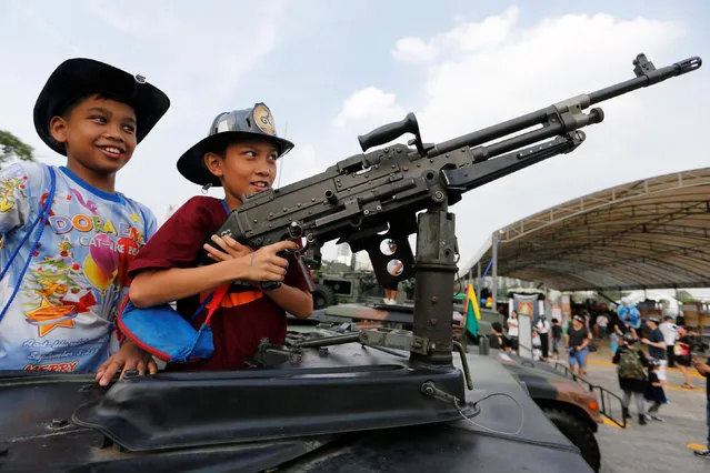 Children play with a weapon on the top of an army vehicle during Children's Day celebration at a military facility in Bangkok, Thailand January 14, 2017. (Photo by Jorge Silva/Reuters)