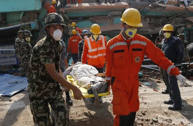 Rescue teams carry a body dug out of the collapsed Sitapyla church in Kathmandu, Nepal, Monday, April 27, 2015. (Photo by Wally Santana/AP Photo)