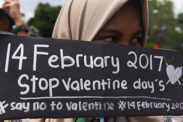 A Muslim student holds a poster during a protest against Valentine's Day celebrations in Surabaya, Indonesia, February 13, 2017. (Photo by Zabur Karuru/Reuters/Antara Foto)