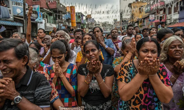 Sri Lankans pray in the street near St Anthony's Shrine one week on from the attacks that killed over 250 people, on April 28, 2019 in Colombo, Sri Lanka. At least 15 people, including six children, were found dead on Saturday morning in the village of Bolivarian on Sri Lanka's east coast after a raid by security forces on a house linked to the Easter suicide bombings. Based on reports, the Islamic State group claimed responsibility for the attacks late on Friday as the hunt for accomplices goes on in eastern Sri Lanka. More than 253 people were killed on Easter Sunday after coordinated terror attacks on three churches and three luxury hotels in the Colombo area and eastern city of Batticaloa, injuring hundreds. (Photo by Carl Court/Getty Images)