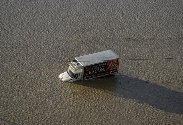 A truck is stranded along a flooded road in Abbotsford, British Columbia, Tuesday, November 16, 2021. (Photo by Jonathan Hayward/The Canadian Press via AP Photo)
