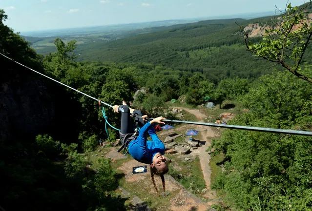 A woman uses a highline during the KisGeri 24 Rock Climbing and Highline Festival in the Kis-Gerecse Quarry in the Gerecse Mountains, northern Hungary, 25 May 2019 (issued on 27 May 2019). The three-day event hosts a six-hour, a 12-hour, and a 24-hour rock climbing competition. (Photo by Balazs Mohai/EPA/EFE)
