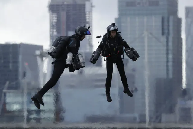 Richard Browning, right, the Founder and Chief Test Pilot of Gravity Industries, who designed and built the world's first patented Jet Suit, and another pilot take part in a demonstration of their technology during London Tech Week 2019 over the Royal Victoria Docks waterway by the ExCel London exhibitions centre in east London, Thursday, June 13, 2019. Gravity Industries plan on staging an International Race Series in early 2020 and see the Royal Victoria Docks waterway as one of the potential race locations. (Photo by Matt Dunham/AP Photo)