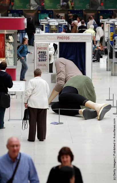 Sculpture of a giant lady with her head stuck in a photo booth