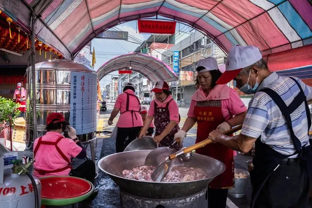 People cook in front of a water station in their neighbourhood during a water ration on April 20, 2021 in Taichung, Taiwan. (Photo by Billy H.C. Kwok/Getty Images)