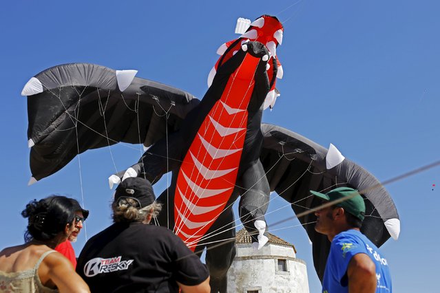 People fly a giant dragon shaped kite during the 13th International Kite Festival at the Moinhos beach in Alcochete near Lisbon, Portugal, June 28, 2015. (Photo by Hugo Correia/Reuters)