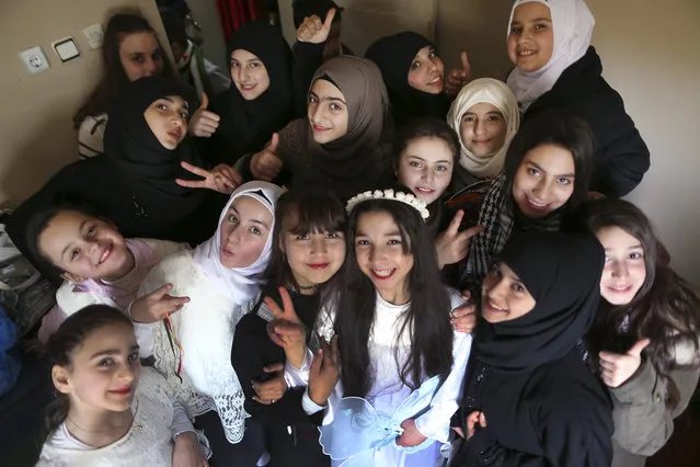 Syrian refugee children pose for a photographer backstage, as they wait their turn to perform during a celebratory ceremony, in Gaziantep, southeastern Turkey, Monday, March 20, 2017. Some Syrians mark March 18 as the anniversary of the uprising against President Bashar Assad, which began six years ago with protests in the southern city of Daraa. Turkey, host to the largest refugee population in the world, including 2.7 million Syrians, is on the front line of the current crisis. (Photo by Lefteris Pitarakis/AP Photo)
