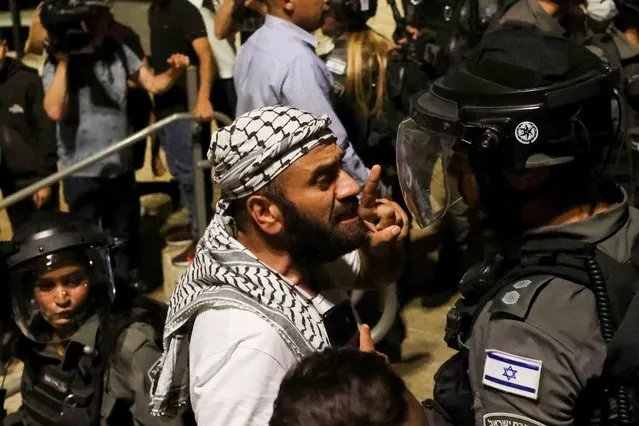 A Palestinian man gestures as he argues with an Israeli border policeman by the entrance to Jerusalem's Old City on May 9, 2021. (Photo by Ronen Zvulun/Reuters)