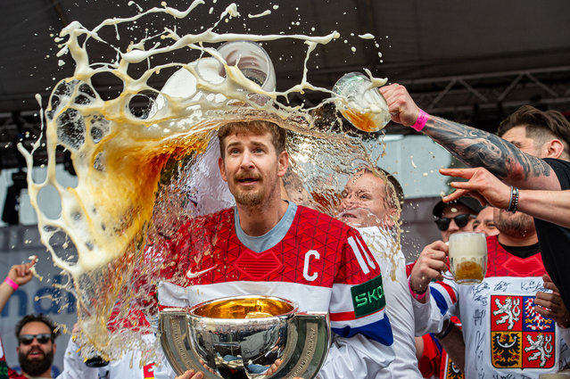 Roman Cervenka #10 of Czechia celebrates with the trophy and gets a beer thrown on him from his teammates during IHF Ice Hockey World Championship gold medal celebrations with fans at Old Town Square on May 27, 2024 in Prague, Czech Republic.  (Photo by RvS.Media/Monika Majer/Getty Images)