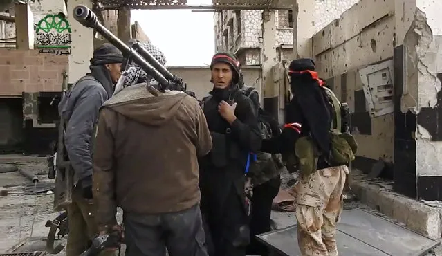 This frame grab from video provided on Tuesday March 21, 2017, by Ahrar al-Sham, Syrian militant group outlet that is consistent with independent AP reporting, shows fighters from Ahrar al-Sham militant group gather during a battle against Syrian government forces, in an eastern neighborhood of Damascus, Syria. Syrian government forces launched a counter-attack against rebels in Damascus on Tuesday, following a rebel suicide car bombing and another insurgent assault earlier in the day in the country's capital, media reports said. (Photo by Ahrar al-Sham/Syrian militant group via AP Photo)