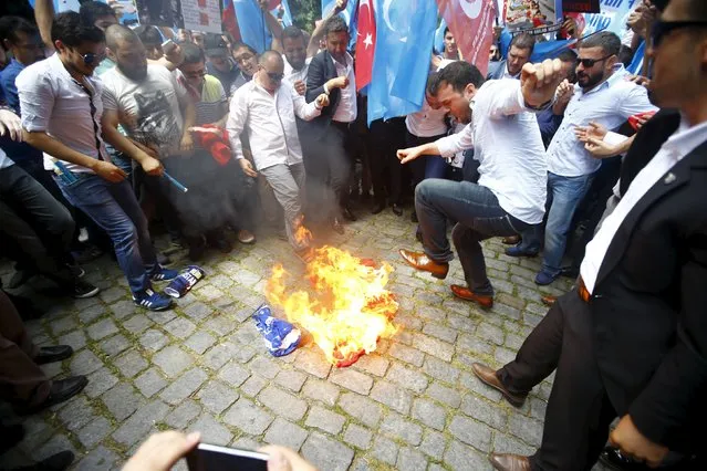 Demonstrators set fire to a Chinese flag during a protest against China near the Chinese Consulate in Istanbul, Turkey July 5, 2015. (Photo by Osman Orsal/Reuters)