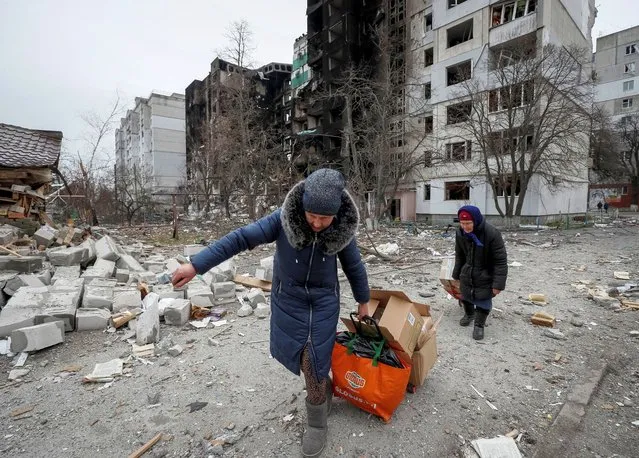 Local residents carry humanitarian aid near destroyed houses in Borodyanka, amid Russia's invasion on Ukraine, in Kyiv region, Ukraine, April 5, 2022. (Photo by Gleb Garanich/Reuters)