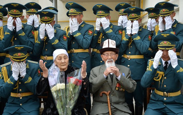 World War Two veteran Aspek Dumashev, 99, pray after congratulations from Kyrgyz servicemen during the Victory Day celebrations in Bishkek on May 8, 2023. Kyrgyzstan will celebrate the 78th anniversary of the 1945 victory over Nazi Germany on May 9. (Photo by Vyacheslav Oseledko/AFP Photo)