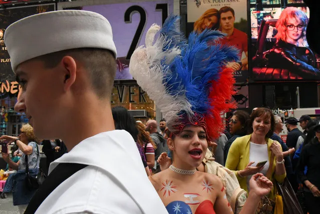 A service member of the United States Navy is seen in Times Square with a woman in a feather head dress in New York City, U.S. May 27, 2017. (Photo by Stephanie Keith/Reuters)