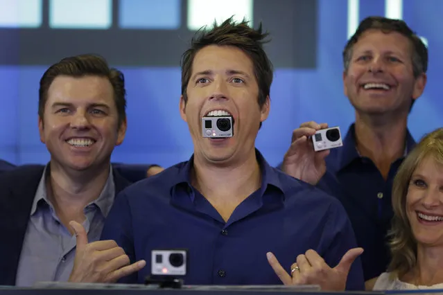 GoPro's CEO Nick Woodman holds a GoPro camera in his mouth as he celebrates his company's IPO at the Nasdaq MarketSite in New York, Thursday, June 26, 2014. GoPro, the maker of wearable sports cameras, loved by mountain climbers, divers, surfers and other extreme sports fans, said late Wednesday it sold 17.8 million shares at $24 each in its initial public offering of stock. (Photo by Seth Wenig/AP Photo)