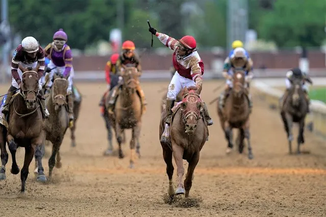 Sonny Leon celebrates after riding Rich Strike   past the finish line to win the 148th running of the Kentucky Derby horse race at Churchill Downs Saturday, May 7, 2022, in Louisville, Ky. (Photo by Charlie Neibergall/AP Photo)