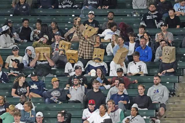 Chicago White Sox fans sit in the stands with bags on their head during the 10th inning of a baseball game between the White Sox and the Los Angeles Angels, Wednesday, September 25, 2024, in Chicago. (Photo by David Banks/AP Photo)