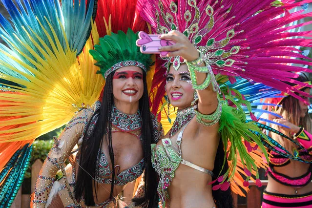 Dancers take a selfie as they wait to perform during the the Notting Hill Carnival in west London, Monday August 26, 2019. (Photo by London News Pictures)