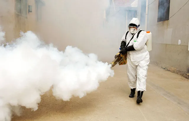 A Chinese volunteer wearing the protective clothing disinfects a street for prevention of the new coronavirus and pneumonia during the Chinese New Year or Spring Festival holiday in Dongxinzhuang Village, Qingdao City, east China's Shandong Province on January 29th, 2020. (Photo by Yu Fangping/Costfoto/Sipa USA)