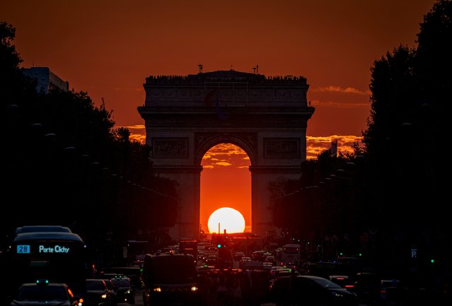 The setting sun, framed by the Arc de Triomphe, illuminates the Champs-Élysées during the 2024 Summer Olympics, Friday, August 2, 2024, in Paris, France. (Photo by Vadim Ghirda/AP Photo)