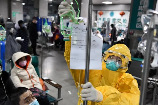 A medical worker in protective suit adjusts a drip bag for a patient at a hospital, following an outbreak of the new coronavirus in Wuhan, Hubei province, China, February 3, 2020. The city of 11 million people is in virtual lockdown and much of Hubei, home to nearly 60 million people, is under some kind of travel curb. (Photo by Reuters/China Daily)