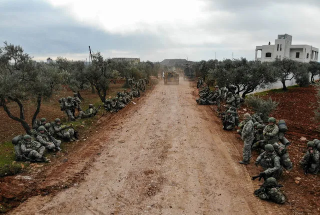 An aerial view shows Turkish soldiers gathering in the village of Qaminas, about 6 kilometres southeast of Idlib city in northwestern Syria on February 10, 2020. The Syrian army took control of a strategic northwestern crossroads town over the weekend, its latest gain in a weeks-long offensive against the country's last major rebel bastion of Idlib. The advance on Saraqeb came shortly after Turkey sent additional troops into the region and threatened to respond if its military observation posts in Idlib, set up under a 2018 truce, come under attack. (Photo by Omar Haj Kadour/AFP Photo)