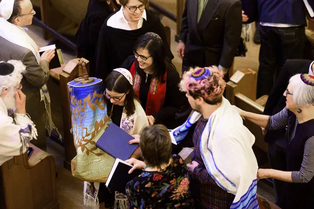 In this Saturday, February 1, 2020, photo, Rabbi Jacqueline Mates-Muchin follows Hanna Raskin as she carries a Torah scroll during her bat mitzvah at Temple Sinai in Oakland, Calif. Mates-Muchin says there’s extra worry as she feels obliged to be constantly mindful of her congregation’s safety.  (Photo by Noah Berger/AP Photo)