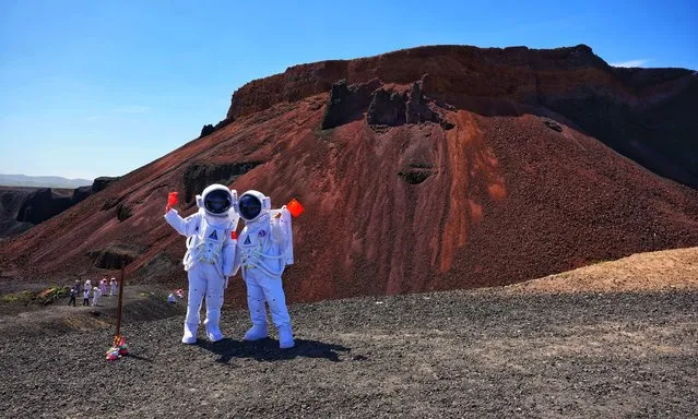 Tourists dressed like astronauts visit Ulan Hada Volcano Geopark on July 16, 2022 in Ulanqab, Inner Mongolia Autonomous Region of China. (Photo by VCG/VCG via Getty Images)
