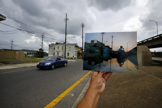 Photographer Carlos Barria holds a print of a photograph he took in 2005, as he matches it up at the same location 10 years on, in New Orleans, United States, August 18, 2015. The print shows Errol Morning sitting on his boat on a flooded street, September 5, 2005, after Hurricane Katrina struck. (Photo by Carlos Barria/Reuters)