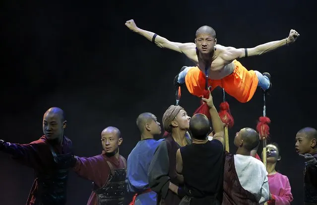 A Shaolin monk is propped up by spears during a media preview of “Shaolin” on Wednesday, July 13, 2016, in Singapore. The show “Shaolin” combines traditional Shaolin kung fu and choreographed moves to music and is inspired by martial arts experts from the Shaolin Temple, said to be the birthplace of Kung Fu. (Photo by Wong Maye-E/AP Photo)
